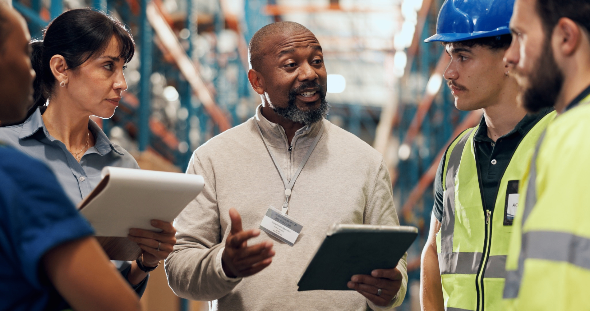 Warehouse team discussing AI-powered order processing on a tablet
